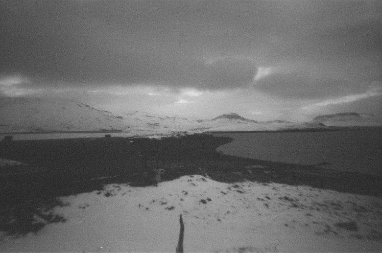 A view over Hvammsvik from the top of the little ridge behind it. You can see the mountains along the fjord but Hvammsvik itself is a bit too dark to identify.