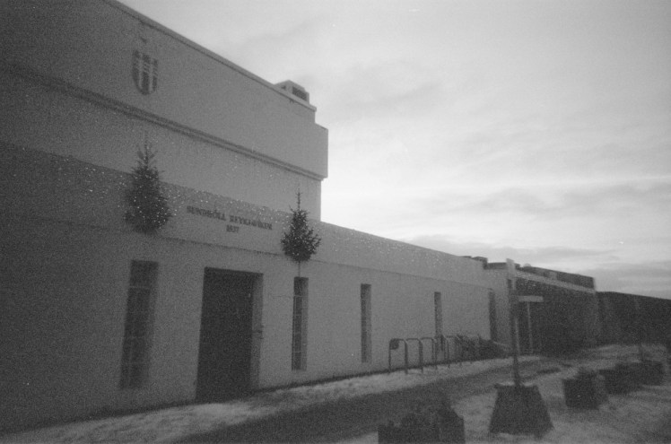 Sundhollin, the Art Deco-style swimming pool in Reykjavik with Christmas trees and lights over the old main door and a sprinkling of snow outside.