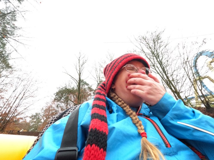 An accidental selfie on L'Oxygénarium, where I'm covering my mouth in a kind of gentle shock. Genuinely accidental selfie, I couldn't let go of the handles long enough to press the camera's button. I'm wearing a long-tailed red and black stripy hat and bright blue waterproof.