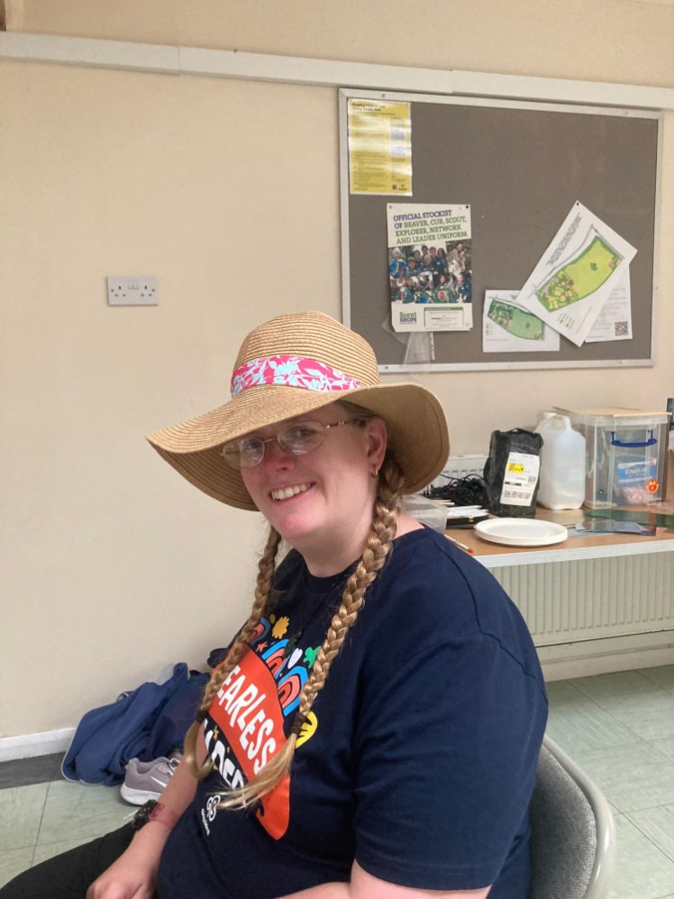 Me in the Scout hall on Brownie camp, wearing my Fearless Leader t-shirt and one of the Brownies' straw hats with a pink band around it.