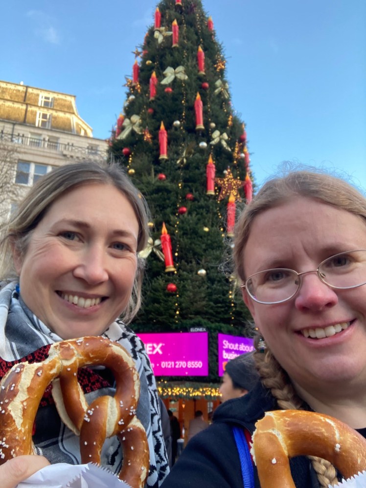 Catherine (left) and I, in front of a giant Christmas tree, holding up our pretzels. Hers is filled with brie and cranberry and mine is just salt.
