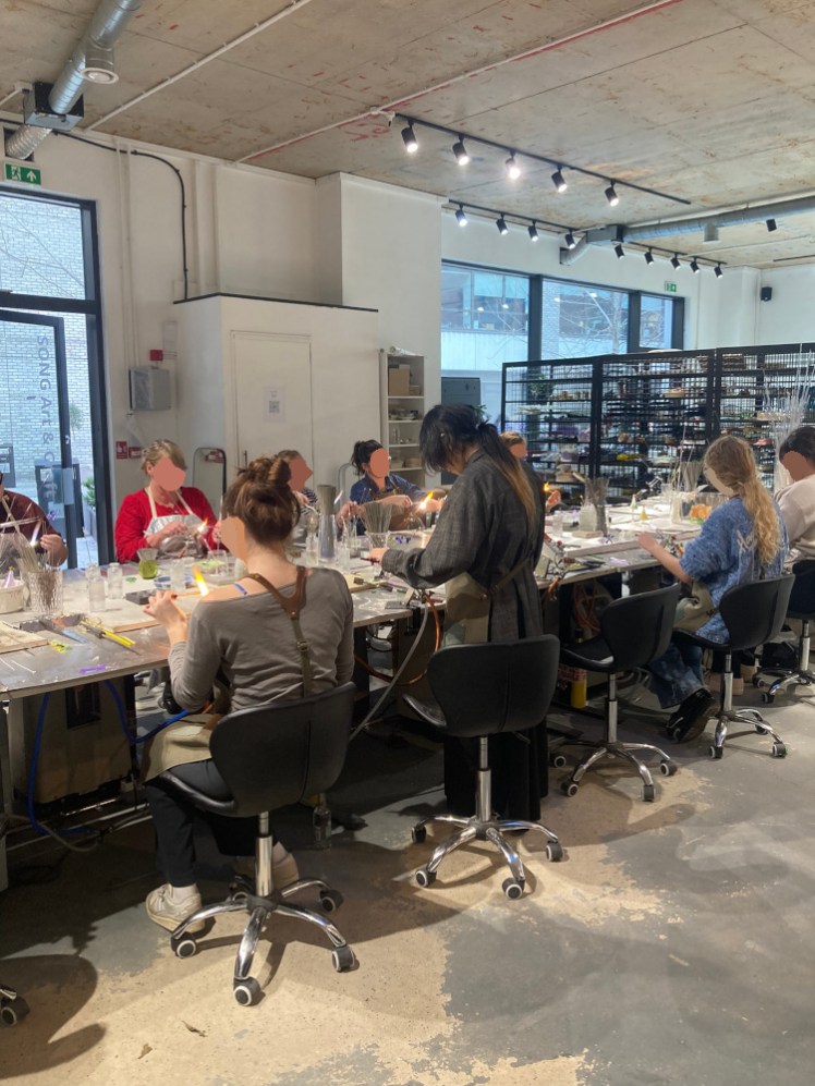 A lampworking class, all wearing aprons and making flowers. I've scribbled over their faces and their purple glasses because they didn't ask for the photos to be used on my blog.
