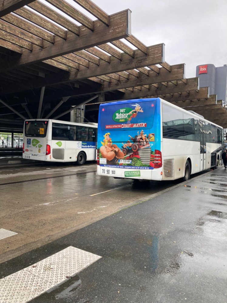 The Parc Asterix shuttle bus, with Asterix decals all over its rear end, parked at Roissypole, the transport hub at Charles de Gaulle Airport's Terminal 3.
