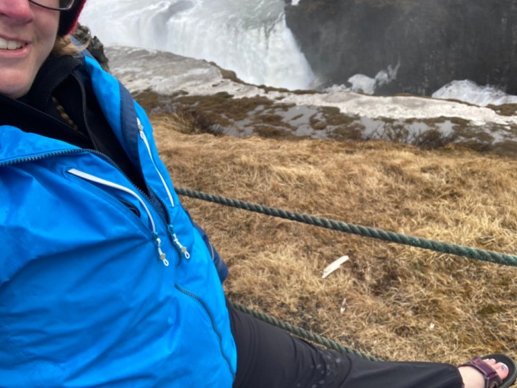 A really awkward selfie so you can see my feet in pink mountain sandals. You can also see the snow around the edges of Gulfoss behind me. Not an ideal day for sandals.