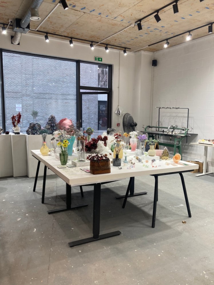 The gallery end of SONG, where a table has been set out with lots of glass, mostly flowers.