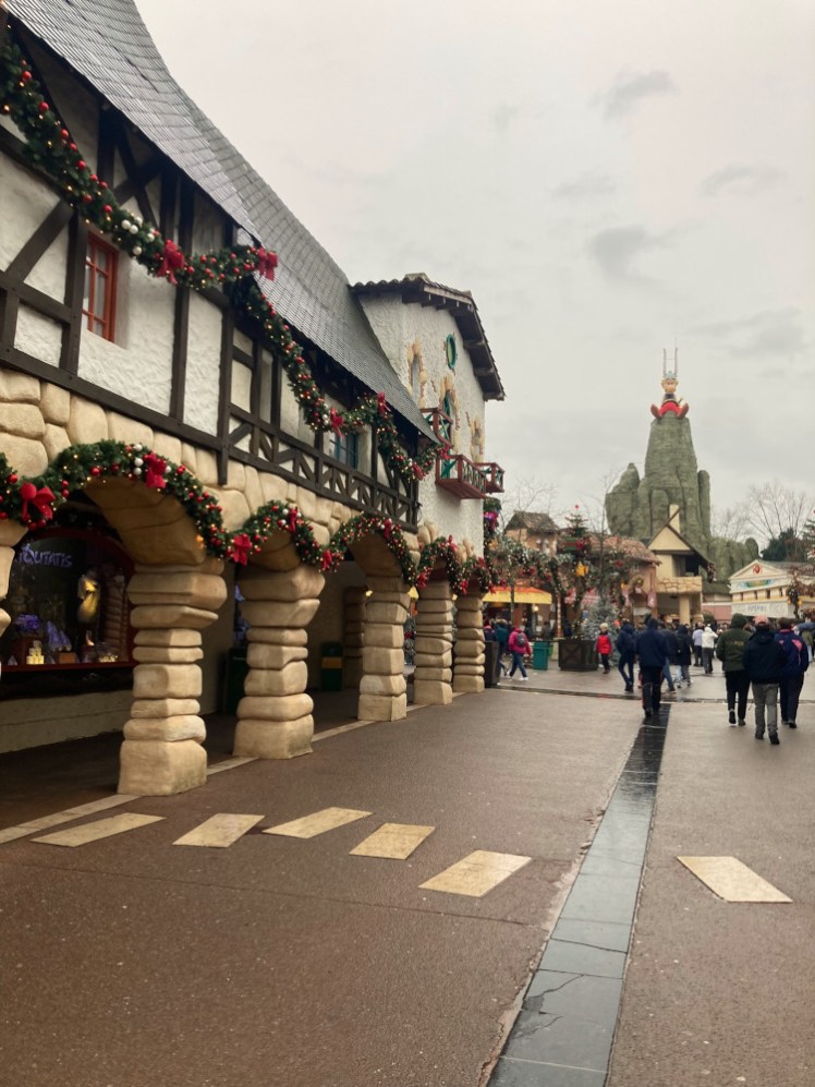 Via Antiqua, the Gallic and/or Roman village right at the entrance, housing most of the shops. In the distance, a giant Asterix is perched on top of a pointed mountain overlooking the park.