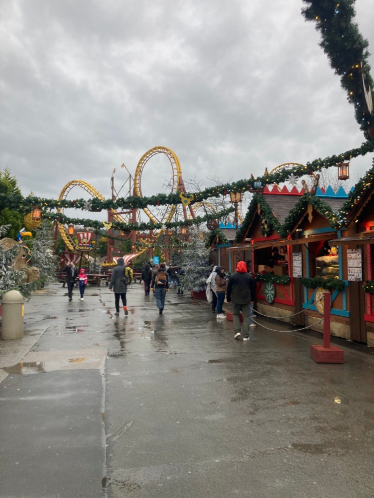 The Christmas market, some wooden kiosks serving sausages and hot drinks, with Goudurix's loops rising up in the background.