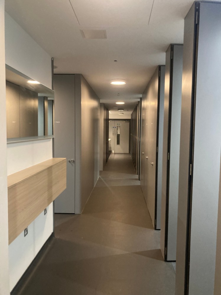Inside the shared bathroom. At first glance, it just looks like a hotel corridor but those grey doors conceal toilets and showers.