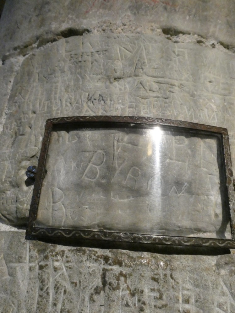 BYRON carved into the stone pillar and protected by a piece of glass in a little frame attached over the name.