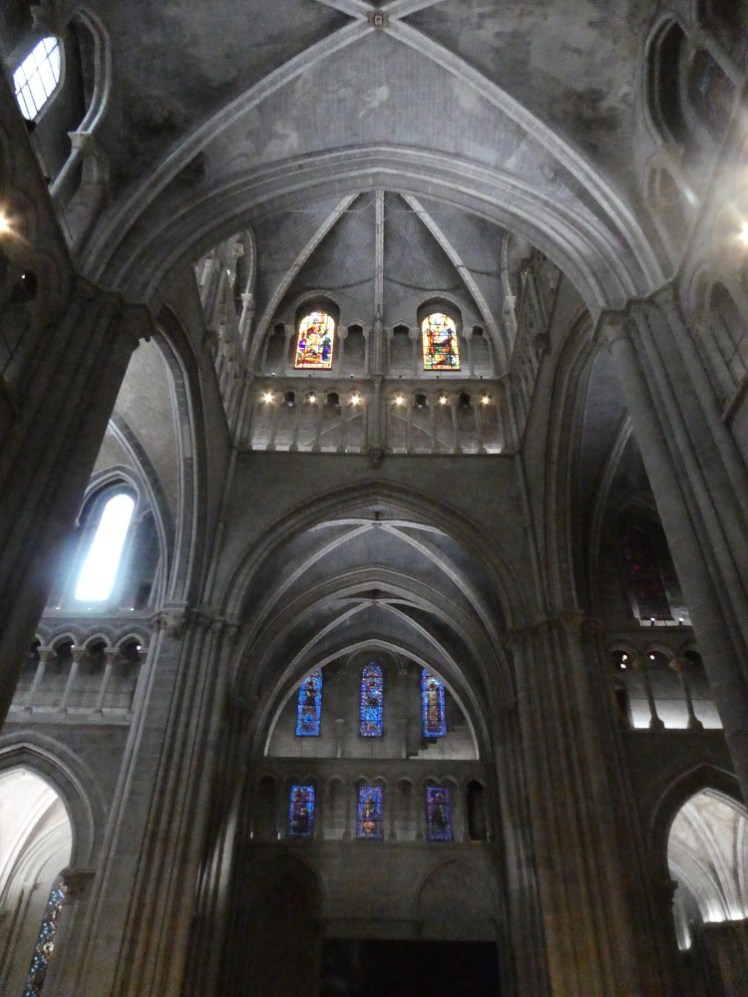 The crossing tower, a high, very grey, very dark tower interior with two windows glowing brightly high up.