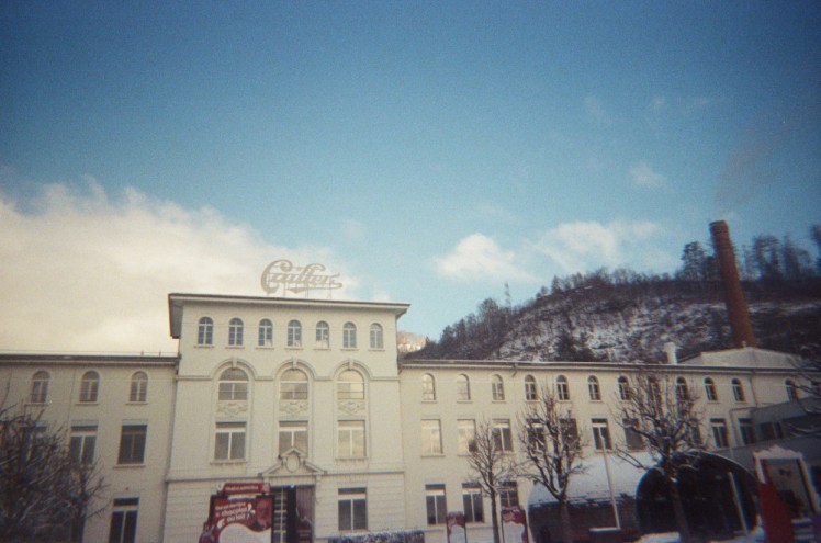 Maison Cailler, a chocolate factory that looks more like a four-storey manor house than a factory, painted white and sitting below a blue sky.