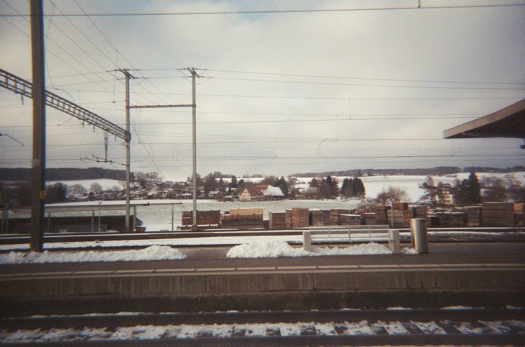 And we finish on yet another station - this time the snowy view taken across a few platforms, tracks and overhead wires towards a snowy town beyond.