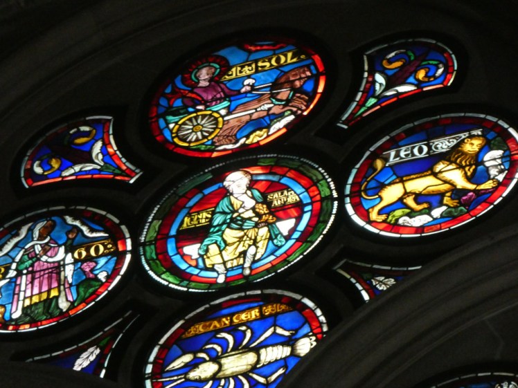 A close-up of one "fan" of the rose window, showing fire surrounded by Leo, Cancer & Virgo with the sun as their matching element.