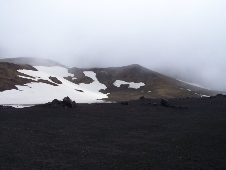 The Askja caldera, with a cloud sitting on it. The snow-patched mountain behind it is part of the older caldera wall.