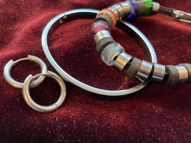 A pair of gunmetal stainless steel hoop earrings, a bangle and my El Camino bracelet, a cord bracelet threaded with stainless steel "steps" as well as an assortment of coloured glass ones representing various experiences and places.