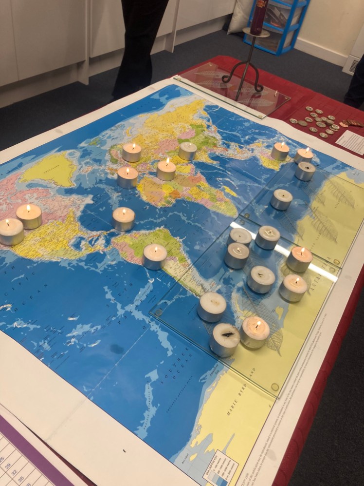 A table with a map on it, covered in tealights to represent all the countries we're thinking of. You can just about make out a tall curly candle at the far end; there's one at each end and they represent Lord & Lady Baden-Powell.