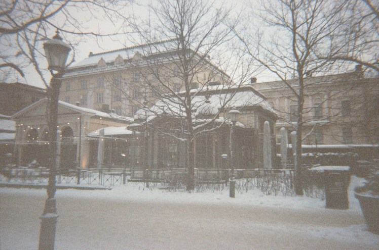 Esplanadi Cafe, a glass pavilion in the park. It's a very snowy day and even the sky is white.