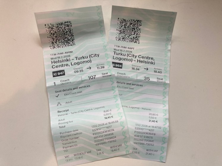 My two Finnish train tickets, laid out next to each other. They're patterned in very pale green and white, have a QR code at the top and a collection of codes at the bottom.