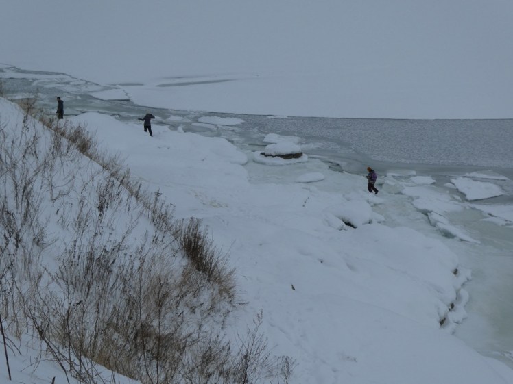 The ice below the cliffs towards the southern end of Suomenlinna, with at least three people walking on the frozen harbour. There are definitely parts where the ice is visibly thicker and safer than other parts; those are not the parts these people are walking on.