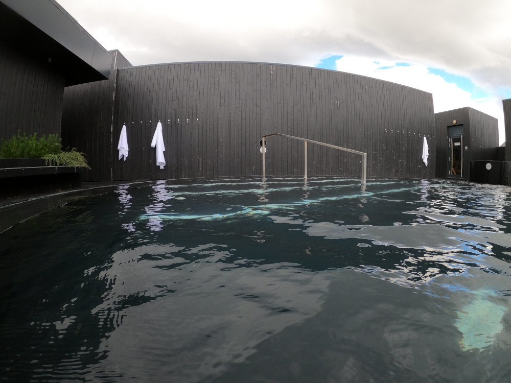 The big warm central pool. The water is quite dark because the pool itself is entirely black and there's a black wooden wall for hanging your robes on behind it.