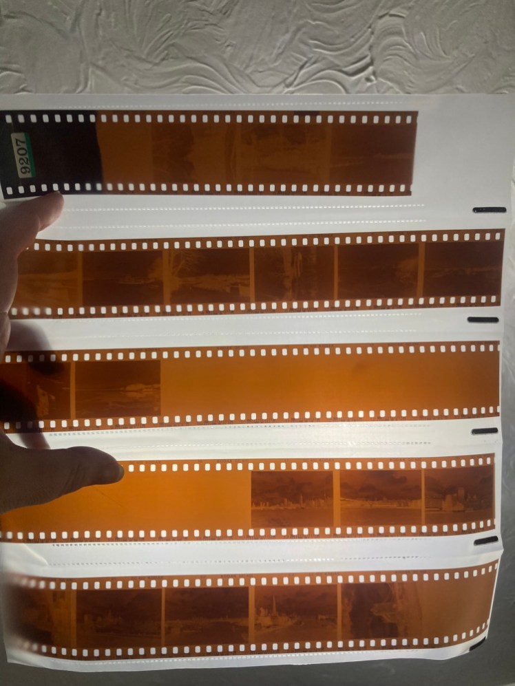 The negatives cut into strips and held up against the Big Light. They have a very obvious huge patch of missing pictures in the middle.