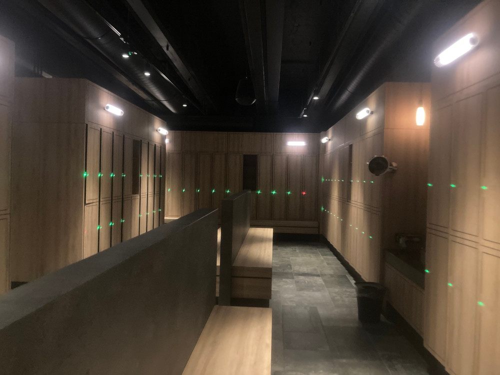 The Sky Lagoon changing rooms (empty). It's dimly lit and each locker has a red or green light showing whether it's taken or not.