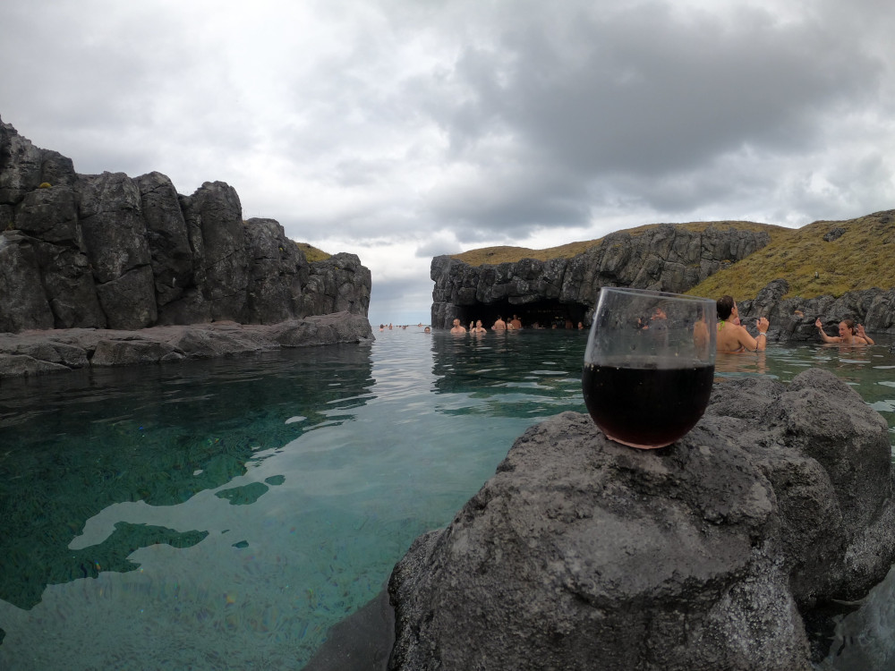 A drink resting on a rock in the little bay with the in-water bar.