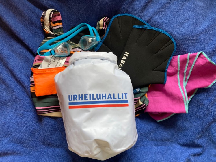 My swimming stuff, all laid out in a towel - stripy swimsuit, gloves, goggles, mini sauna towel, coin & card purse and the Urheiluhallit bag on top.