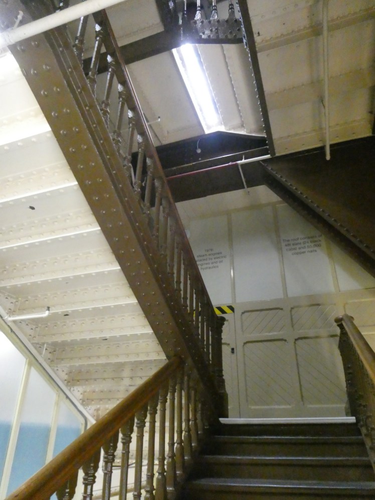 The stairs inside South Tower. The underside of the stairs are painted white and the banisters and steps are chocolate brown. They're quite wide and open and light and airy.