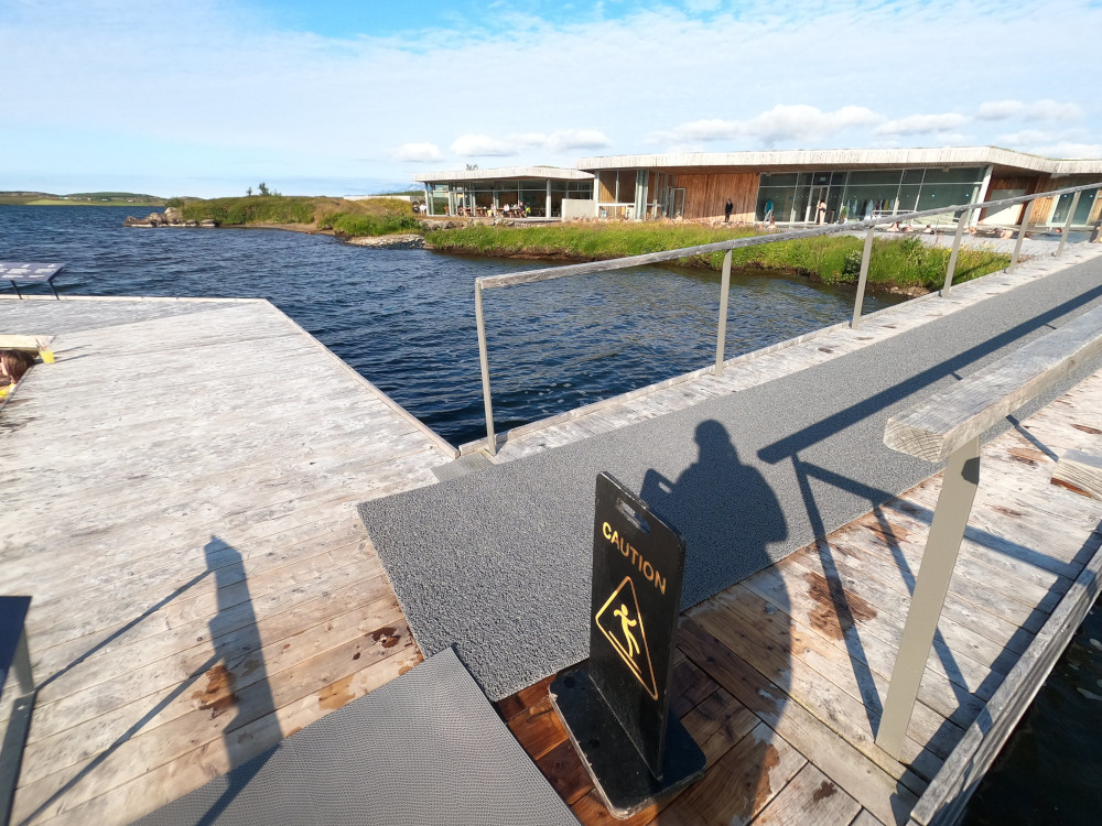 The bridge across the lake to the hexagonal pools with the landside pools and buildings on the other side.