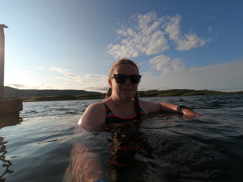 A selfie on the infinity edge of the pool where you can't tell where the hexagonal pool ends and the lake begins.