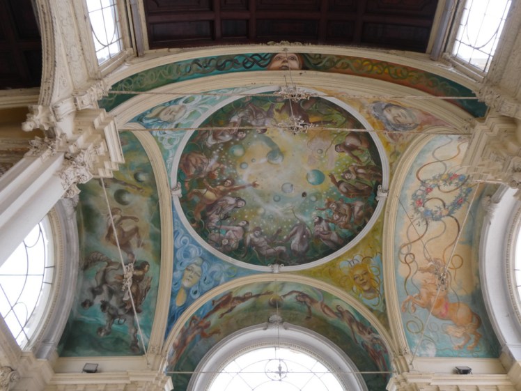 The ceiling in the Colonnades, painted with a central picture of full-figured people reaching out for bubbles and with women or goddesses in each corner, all of them with unlikely coloured hair - bottom left is blue, for instance.