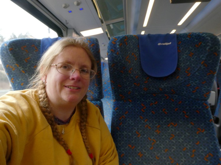 A selfie in my yellow jumper on the train to Mariánské Lázně. The seats are dark blue and big and comfortable.