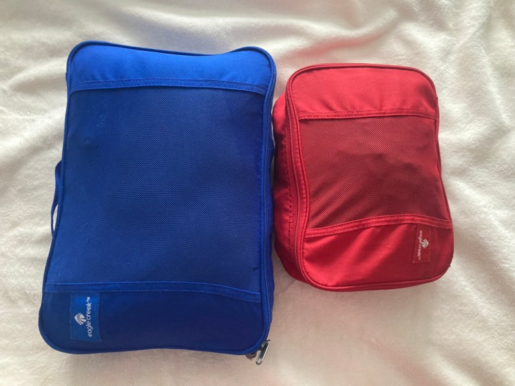 Two packing cubes - a large blue one containing my clothes and a smaller red one containing my underwear.