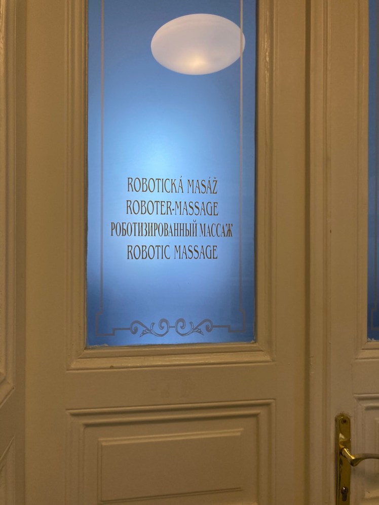 A white panelled door with a frosted glass window in it. The window is faintly lit in blue from behind and has etched decorative borders but more importantly, it says "Robotic massage" in four languages. I wish I knew what a robotic massage actually involved.