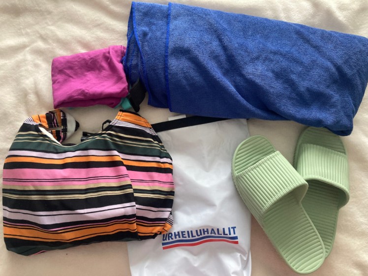 My swimming stuff - a stripy swimsuit, a tiny purple towel and a big blue towel, along with my Finnish drybag and green pool shoes.