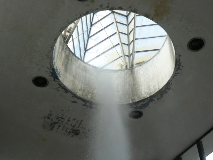 The Vřídlo hot spring erupting up into a circular cutout in the ceiling above it. It's all a bit mildewy and the paint stripped off when you look carefully.