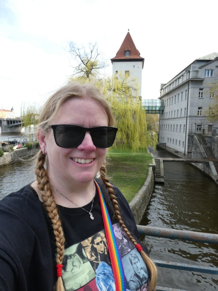 A selfie in the spot where Ethan phoned Kittridge. There's a lock in the river behind me with a tower and a willow tree.