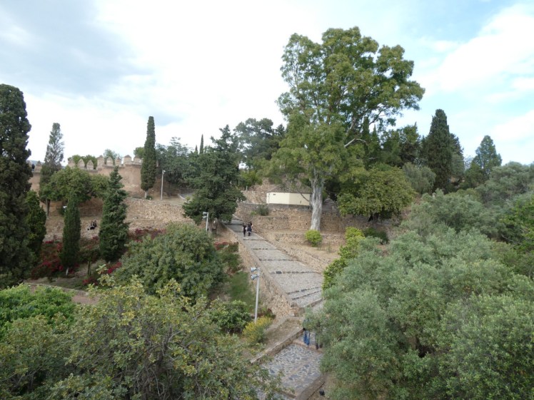 Inside the Gibralfaro, where walls and cobbled slopes are almost hiding underneath trees.