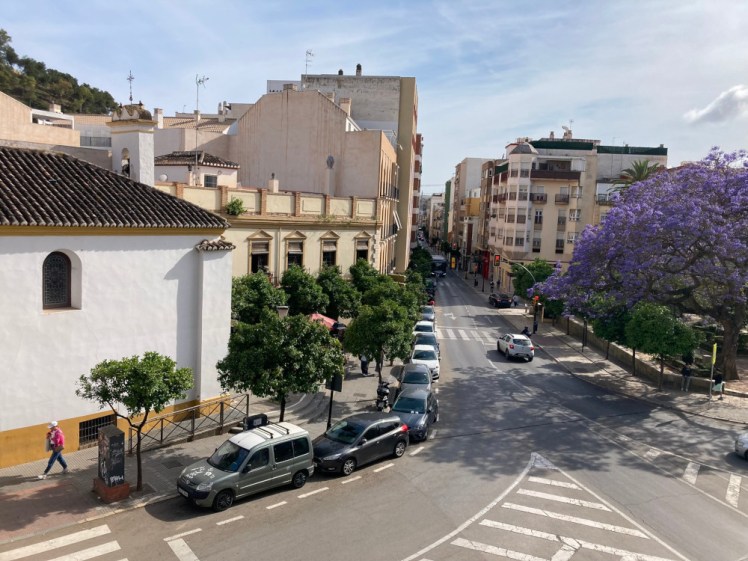The view from our living room windows, overlooking the Jardin de los Monos with its purple jacaranda trees, Calle Victoria, a small church and just a hint (from this angle) of the Gibralfaro on the hill to the left.