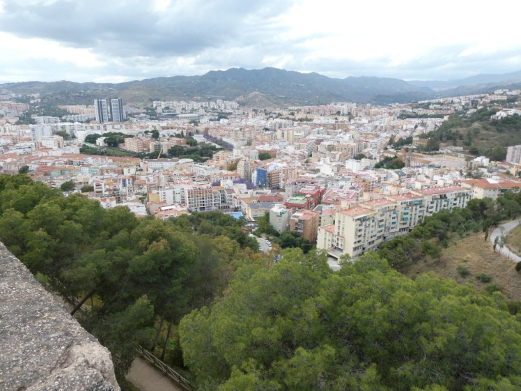 Views down over the busy north-central part of Malaga city with mountains rising up behind them.
