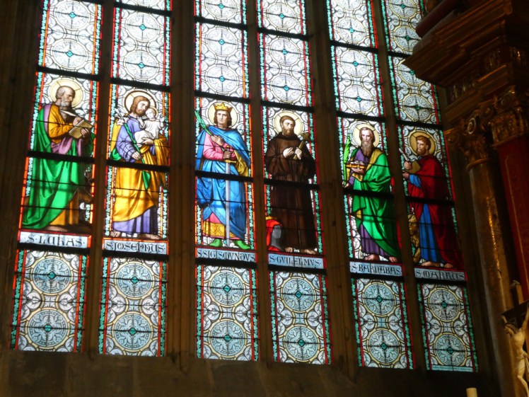 A window in one of the ambulatory chapels. It's mostly just decorative patterns but the second line up is a line of saints, their names underneath them, clad mostly in colourful robes and looking lovely.