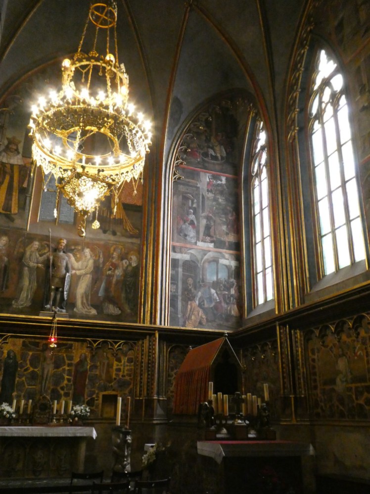 St Wenceslaus Chapel, a large high-ceilinged side chapel made dark by elaborate frescoes on the upper walls and jewels and gold decoration on the lower. The star of the show as far as I'm concerned is a very bright, very gold chandelier.