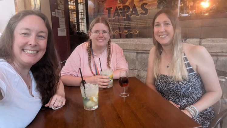 The three of us sitting at a tapas bar with drinks, waiting for the food to arrive. Just to prove it, you can see the word "Tapas" in the tiled mural right behind my head.