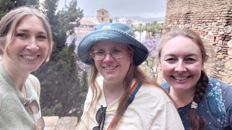Catherine, me and Esther taking a triple selfie on the walls of the Alcazaba. Catherine is wearing a very pale green jumper, I'm wearing a yellow t-shirt and a denim bucket hat with my hair down for once and Esther is wearing a polka dotted navy t-shirt.