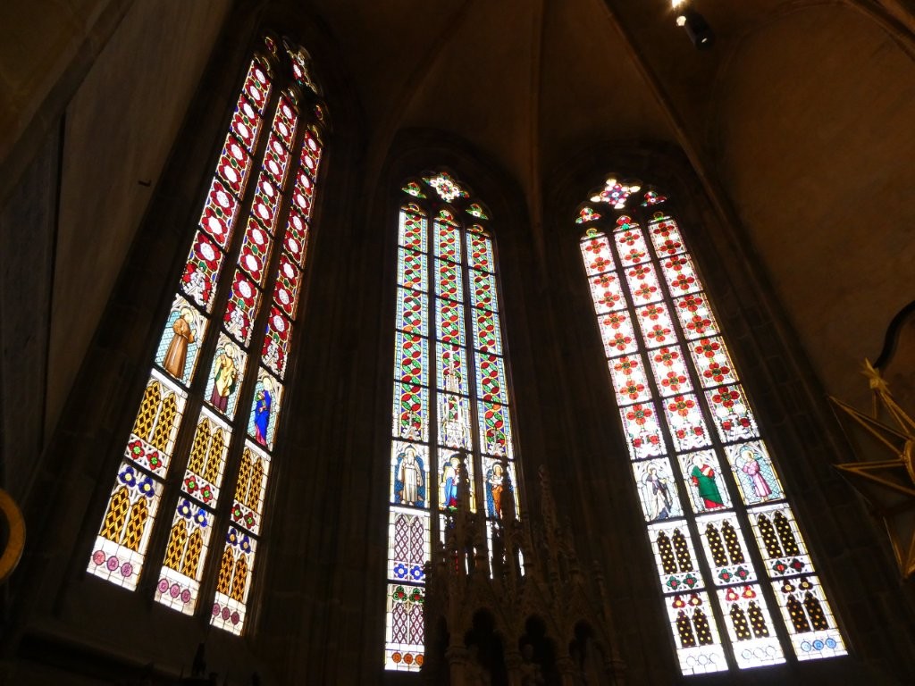 Three even taller thinner windows mostly featuring geometric and floral patterns but the third line up features a row of saints.