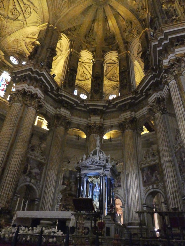 The altarpiece in the apse, a pillared stand with a figure within it, surrounded by the decorative arches enclosing the altar.