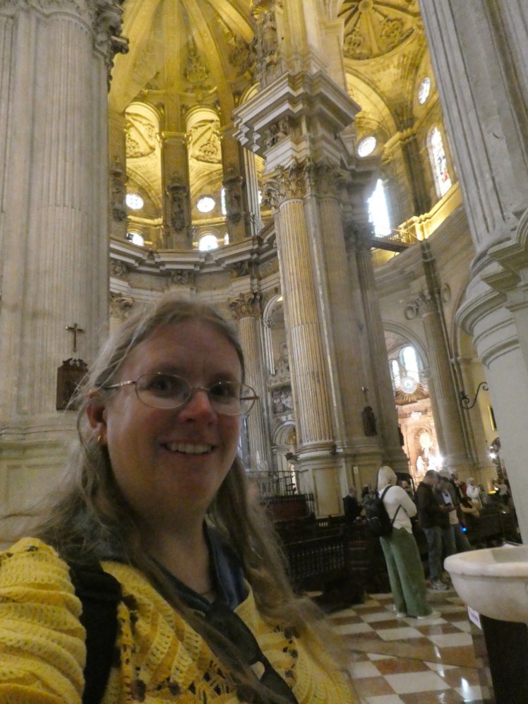 A selfie (wearing a crochet yellow banana jumper) with the decorative altar end in the apse.