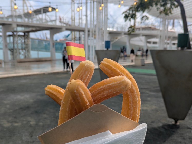 A packet of churros with a little Spanish flag on a cocktail stick poking out.