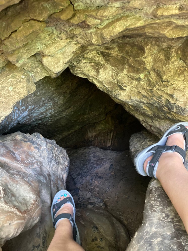 My feet in black and white Karrimor sandals, stretched out in the entrance to Goatchurch Cavern, Mendips.